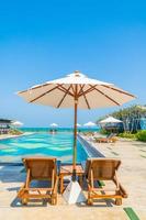 Beautiful umbrella and chair around swimming pool in hotel and resort