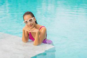 retrato, hermoso, joven, mujer asiática, relajarse, sonrisa, alrededor, piscina al aire libre, en, hotel, resort foto