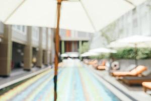 Abstract blur and defocused umbrella and chair around swimming pool photo