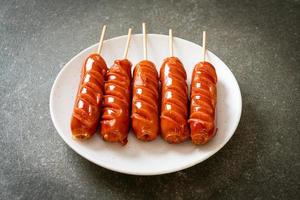 Fried sausage skewer on white plate photo