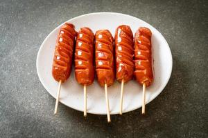 Fried sausage skewer on white plate photo