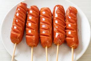 Fried sausage skewer on white plate photo