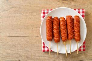 Fried sausage skewer on white plate photo