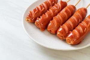 Fried sausage skewer on white plate photo