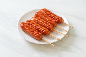 Fried sausage skewer on white plate photo