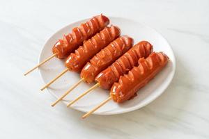 Fried sausage skewer on white plate