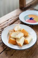 Steamed toast bread with colourful custard on wood background photo