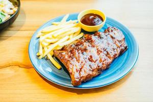 BBQ a la parrilla o costilla a la barbacoa con papas fritas foto