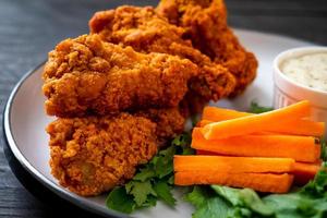 Fried spicy chicken wings with vegetable photo