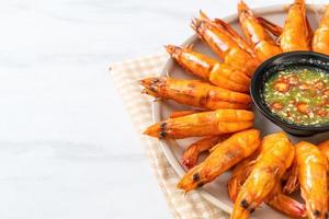 Baked salted shrimps or prawns with seafood spicy sauce - seafood style photo