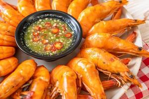 Baked salted shrimps or prawns with seafood spicy sauce - seafood style photo