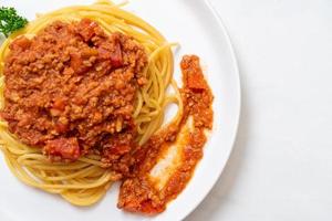 espaguetis de cerdo a la boloñesa o espaguetis con salsa de tomate de cerdo picada - estilo de comida italiana foto