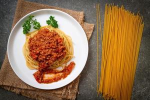 espaguetis de cerdo a la boloñesa o espaguetis con salsa de tomate de cerdo picada - estilo de comida italiana foto