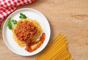 espaguetis de cerdo a la boloñesa o espaguetis con salsa de tomate de cerdo picada - estilo de comida italiana foto