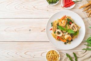 fideos picantes salteados con mariscos o pad cha talay - estilo de comida tailandesa foto