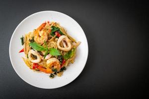 fideos picantes salteados con mariscos o pad cha talay - estilo de comida tailandesa foto