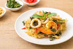 fideos picantes salteados con mariscos o pad cha talay - estilo de comida tailandesa foto