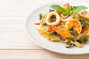 fideos picantes salteados con mariscos o pad cha talay - estilo de comida tailandesa foto