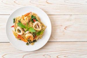 Stir-fried spicy noodles with sea food, or Pad Cha Talay - Thai food style photo