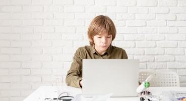 niño trabajando o estudiando en la computadora portátil en casa