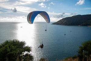 Paragliding over sea with beautiful blue sky background at Phuket, Thailand
