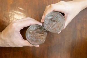 Close up of hand is holding glasses of cold water photo