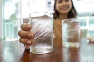 Close up of hand is holding glasses of cold water photo