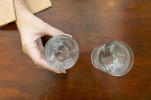 Close up of hand is holding glasses of cold water photo