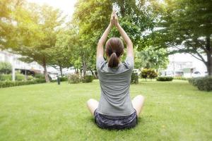 Cerca de una mujer haciendo yoga en un jardín verde foto