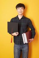 University man is happy with graduation on yellow background photo