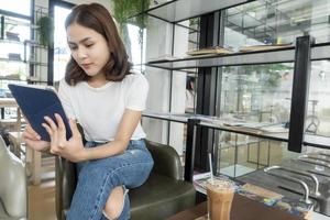 Beautiful business girl working with tablet , smartphone and drinking coffee in coffee shop photo