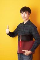 University man is happy with graduation on yellow background photo