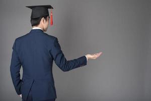 El hombre de negocios está sosteniendo un sombrero de graduación, concepto de educación empresarial foto