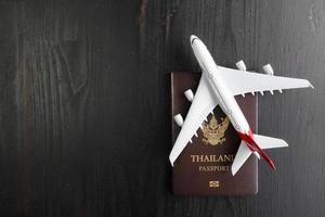 Airplane model and passport on wooden desk, ready travel concept photo