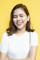 Retrato de hermosa estudiante universitaria están sonriendo sobre fondo de pared amarilla