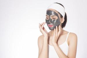 Bella mujer enmascarando su rostro sobre fondo blanco. foto