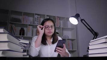 femme asiatique stressée assise et utilisant un smartphone video