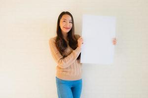 Retrato hermosas mujeres asiáticas jóvenes muestran tablero de papel blanco en blanco foto