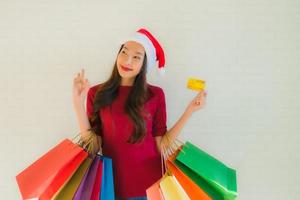 Retrato de hermosas mujeres asiáticas jóvenes usan gorro de Papá Noel de Navidad con bolsa foto
