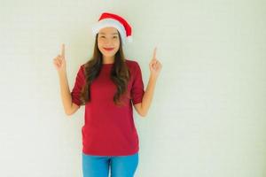 Retrato de hermosas mujeres asiáticas jóvenes vistiendo gorro de Papá Noel para la celebración de Navidad foto