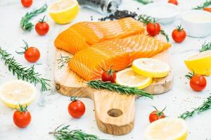 Raw and fresh salmon meat fillet on wooden cutting board photo