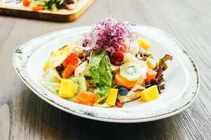 Ensalada de frutas con verduras en plato foto