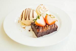 Vanilla ice cream with chocolate brownie cake with strawberry on top photo