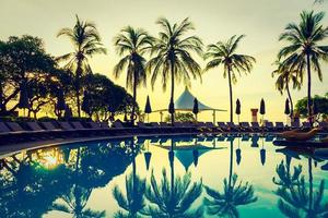 Silhouette coconut palm tree around swimming pool photo