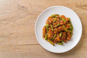 Stir fried pork and red curry paste with sting bean photo