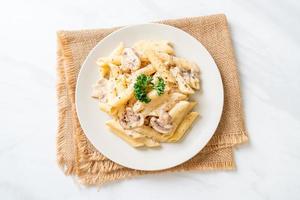 Penne pasta carbonara cream sauce with mushroom - Italian food style photo