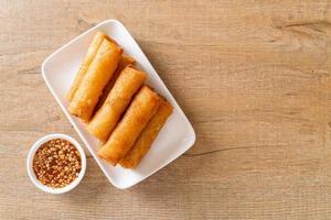 Deep-fried spring roll with sauce on white plate photo