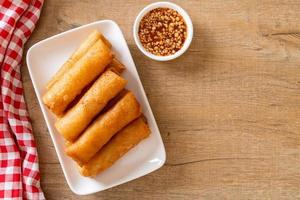 Deep-fried spring roll with sauce on white plate photo