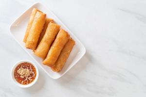 Deep-fried spring roll with sauce on white plate photo