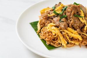 Stir-fried instant noodle with pork and egg - Asian local street food style photo